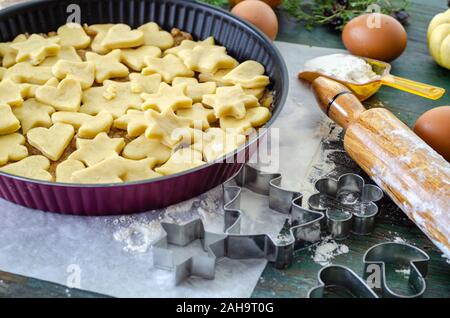 Apple pie ready to be baked in the oven, It  is covered with star and heart shaped cookies Stock Photo