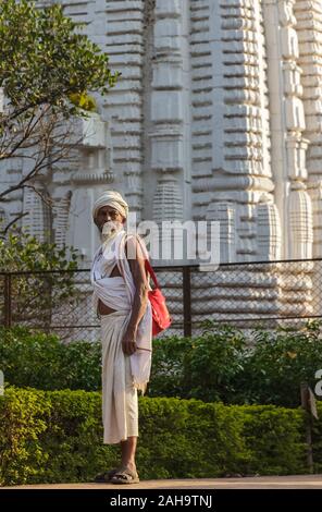 Bhubaneshwar, Orissa, India - February 2018: A candid portrait of an aged pilgrim with the backdrop of an ancient temple. Stock Photo