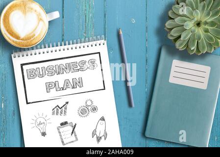 business strategy concept, top view of business plan on notepad on rustic wooden table Stock Photo