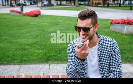 Man sending audio message with mobile Stock Photo