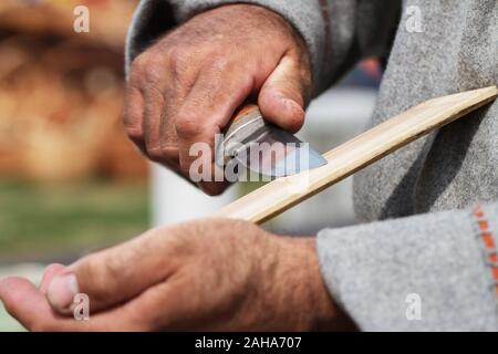 Man sharpened steel knife on whetstone. Stock Photo
