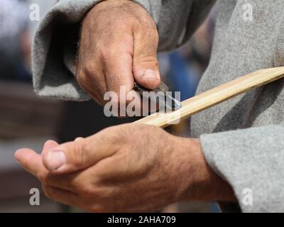 Man sharpened steel knife on whetstone. Stock Photo