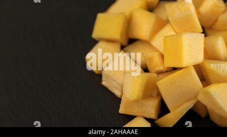 Fresh pineapple cube slices on the black background. Pineapple chunks close up Stock Photo