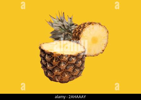 Pineapple half. Cut pineapple isolated on yellow. Pineapple with leaves. Stock Photo