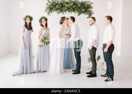 Soulful photo of the newlyweds hugging and kissing each other during the wedding ceremony. Stock Photo