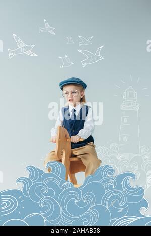 kid in retro vest and cap riding on rocking horse on grey background with fantasy lighthouse, waves and flying birds illustration Stock Photo