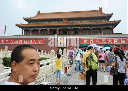 06.08.2012, Beijing, , China - Tourists outside the Forbidden City in Tiananmen Square with a portrait of Chairman Mao above the entrance. 0SL120806D0 Stock Photo