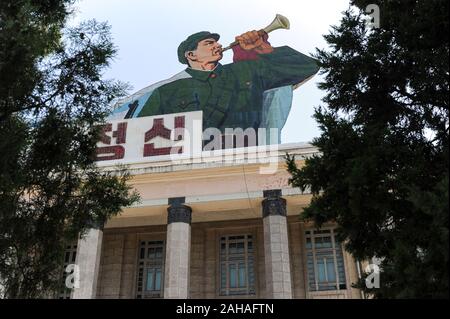 08.08.2012, Pjoengjang, , North Korea - A propaganda poster with fanfare players in soldier's uniform on Kim Il Sung Square in the North Korean capita Stock Photo
