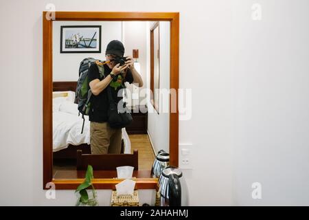 The traveler is taking a picture of herself reflected in the mirror. Stock Photo