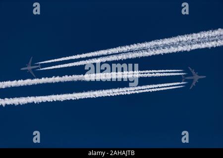 Two airplanes with contrails in the blue sky Stock Photo