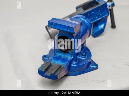 Parts of disassembled metal vise on the table in the workshop. Heavy Tool Repair Stock Photo