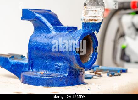 Parts of disassembled metal vise on the table in the workshop. Heavy Tool Repair Stock Photo
