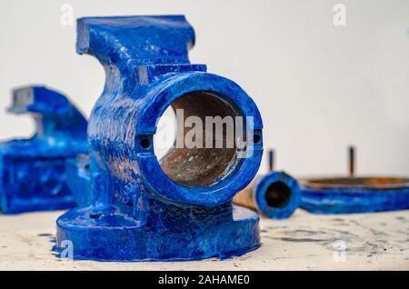 Parts of disassembled metal vise on the table in the workshop. Heavy Tool Repair Stock Photo