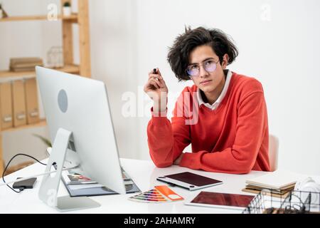 Creative designer looking at you while concentrating on work over new website Stock Photo