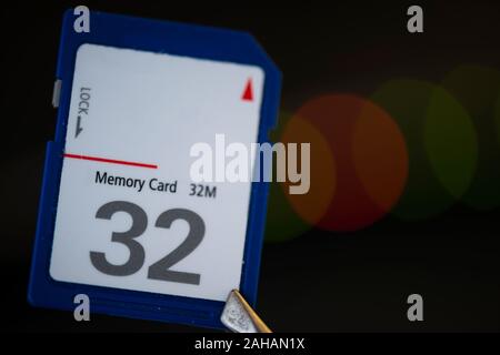 Close up view of low storage blue 32 MB micro or macro compact flash memory card as out-of-date nostalgic technology concept. Stock Photo