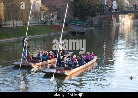 Two punts full of tourists on the River Cam in Cambridge travel side by side down the river Stock Photo