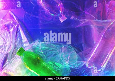 Plastic bottles on plastic background in neon lights. Zero waste concept. Top view. Stock Photo