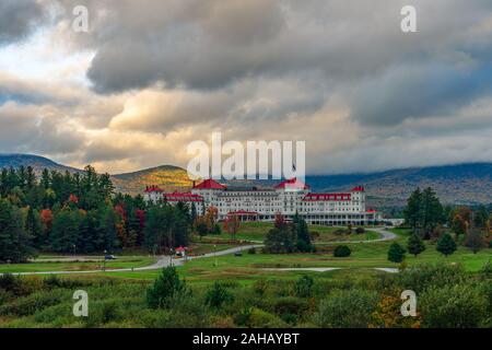 A break in the clouds allows golden sunlight to illuminate the mountside behind the iconic Mount Washington Hotel. Stock Photo