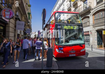 People getting on a Tour Bus at a Bus Stop in Madrid, Spain Stock Photo