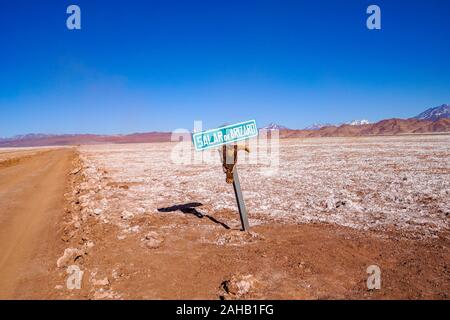 A signpost with a skull attached marks the dirt road across the Salar de Arizaro salt flats, near Tolar Grande in the high altitude desert of Salta's puna region in Argentina Stock Photo