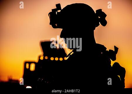A U.S. Marine with 2nd Battalion, 7th Marines, is silhouetted against the rising sun during a tactical vehicle driving course December 21, 2019 in Kuwait. Stock Photo