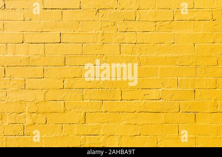 Retro bright yellow painted brick wall background texture Stock Photo