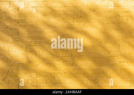 Shadow and light on yellow brick wall background texture Stock Photo