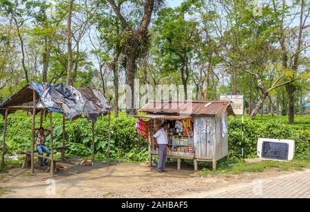 Typical small dilapidated roadside hut stall with a customer selling biscuits and crisps in Kaziranga, Golaghat District, Bochagaon, Assam, India Stock Photo