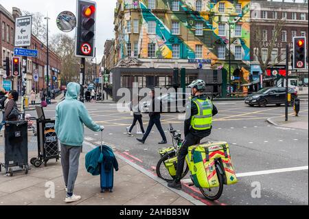London Ambulance Paramedic on a push bike stopped at traffic lights near Kings Cross Station, London, UK. Stock Photo