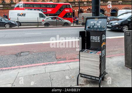 Pile of London Evening Standard Newspapers on a stand on a busy street in St.Pancras, London, UK. Stock Photo