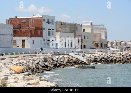 A view of the rocky shoreline and whitewashed buildings of the old city of Mahdia on the Mediterranean coast of Tunisia. Stock Photo