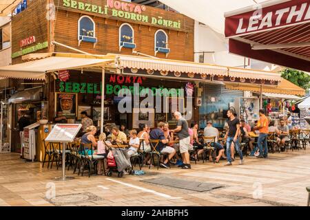 Bodrum, Turkey - September 23rd 2019: People eating and drinking in a busy cafe restaurant. The town is a popular tourist destination Stock Photo