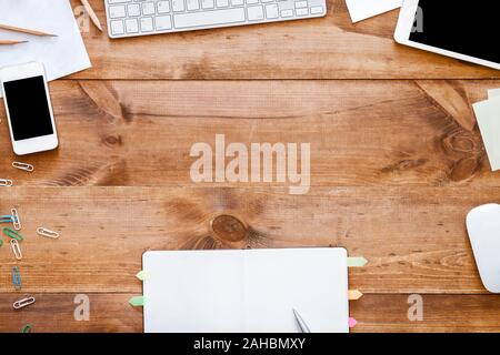 Business work table with devices and open notebook, top view Stock Photo