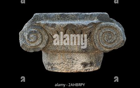 ancient greek ionic style basalt stone capital from the katzrin open air museum in the golan heights in israel isolated on a black background Stock Photo