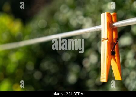a clothespin hanging on a wire in the garden Stock Photo