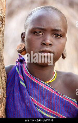 Portrait of a suri tribe woman with enlarged earlobes and huge earrings ...