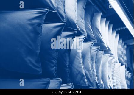 Classic blue tone pillows on shelves showcases. cushions in trendy 2020 year color Stock Photo