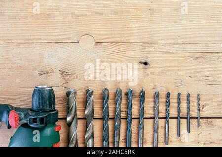 Set of drill bits on wooden background Stock Photo