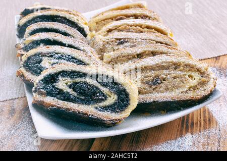 Poppy seed roll and wallnut roll on wooden table Stock Photo