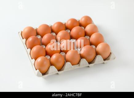 Twenty fresh brown eggs in a paper egg tray Stock Photo
