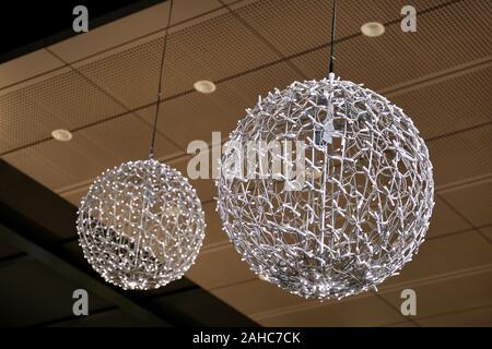 Light street decoration. New Year string white rice lights bulbs in the form of a round chandelier. Decorations for Christmas celebration. Stock Photo