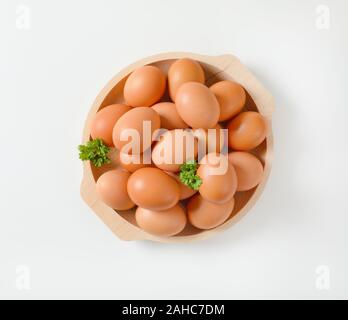 Fresh brown eggs in wooden bowl Stock Photo