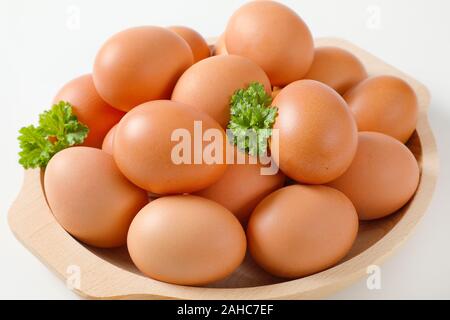 Fresh brown eggs in wooden bowl Stock Photo