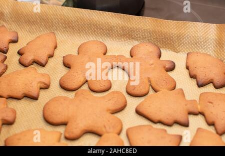 gingerbread cookie festive cooked at home. gingerbread men hold hands. Warm light, selective focus. Stock Photo