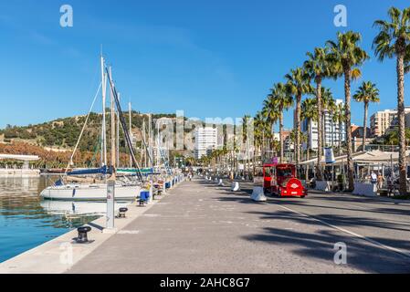 Malaga, Spain - December 4, 2018: Yachts and people at the Paseo del Muelle Uno (Pier One Walk), a beachfront shopping and leisure area in Malaga, And Stock Photo