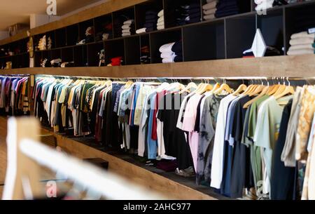 Men clothing shop, casual clothes on hangers and shelves in apparel store  Stock Photo