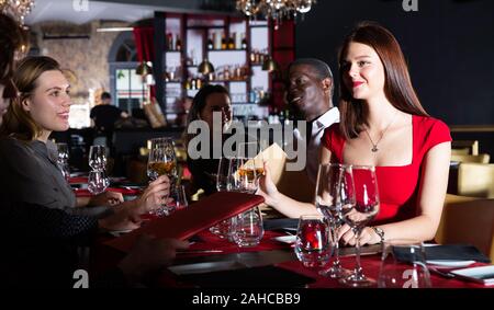 Two positive couples having dinner and nice talking in restaurant Stock Photo