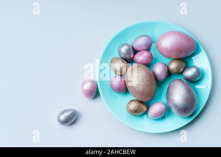 Colored chicken and quail eggs of pink, silver, golden and blue color  Stock Photo