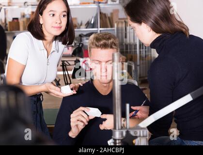 Students and teacher of architecture faculty discussing details of architectural model in university workshop Stock Photo