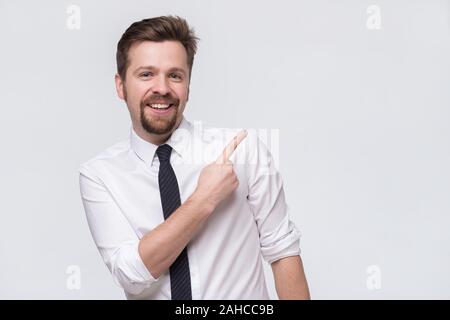 Stylish handsome young caucasian man pointing aside. Stock Photo